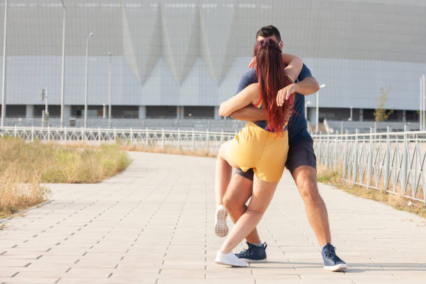 Couple dancing at sunset salsa brazilian zouk. Lovers, dance partners spinning, latin festival dance concept. Social dancing.